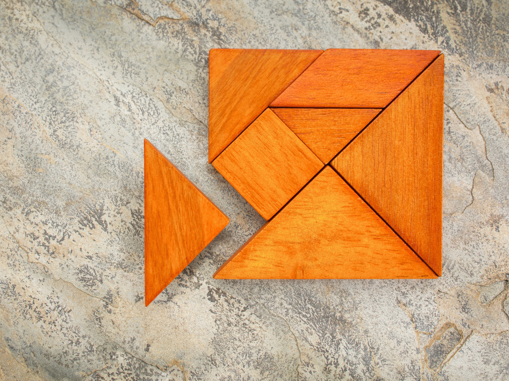 Wooden tangram puzzle with one missing piece, symbolizing strategic problem-solving, AI planning, and building complete business solutions.