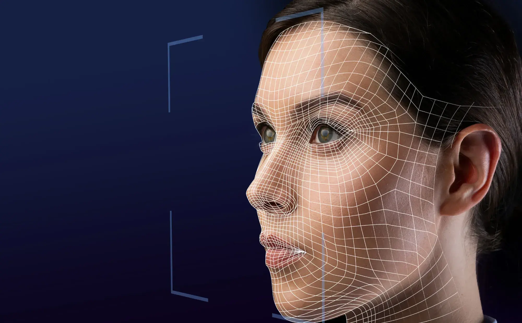 Black and white image of a woman's face in profile with a digital wireframe overlay, symbolizing facial recognition technology. The tone is technological and futuristic.